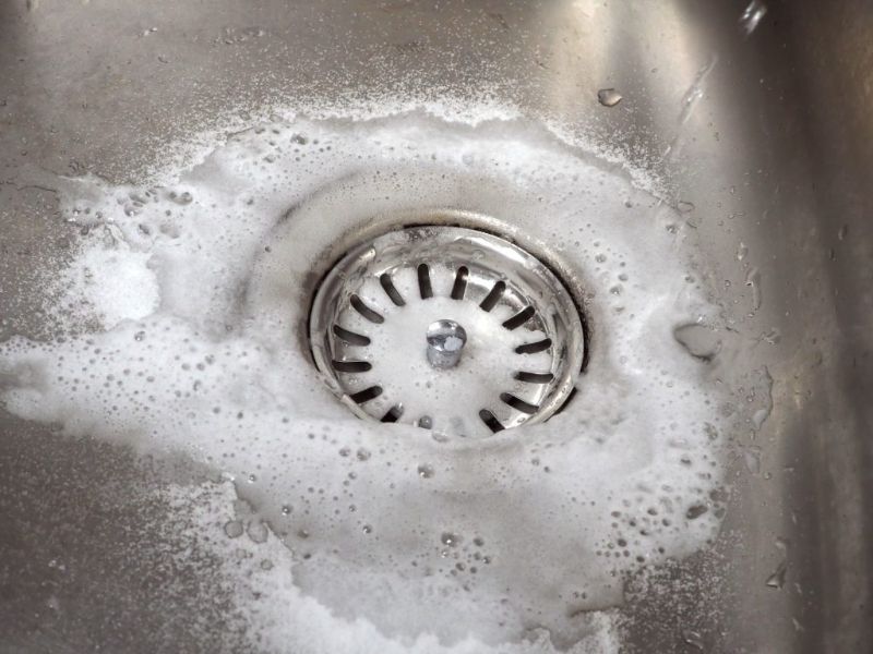 Làm sạch khu vực miệng thoát nước bằng baking soda và nước nóng