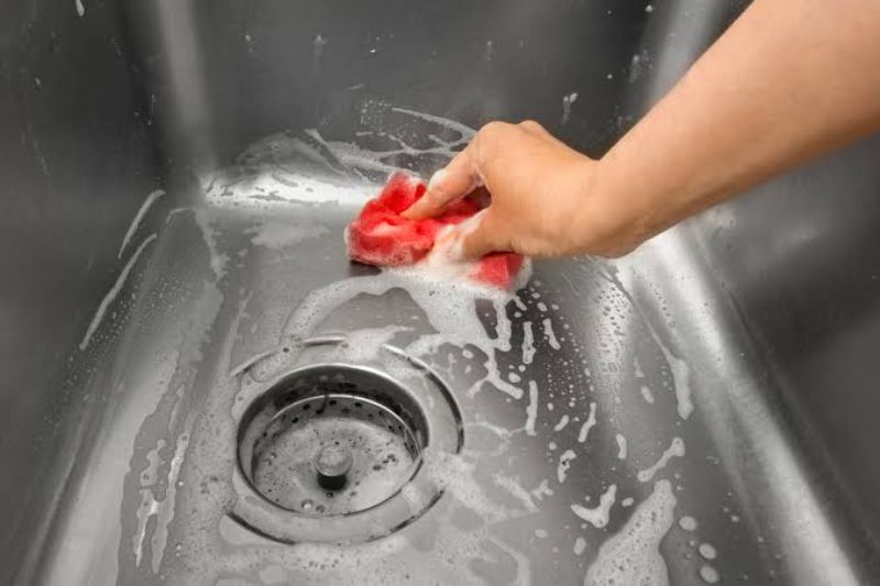 Làm sạch bồn rửa bát bằng nước rửa chén và nước ấm
